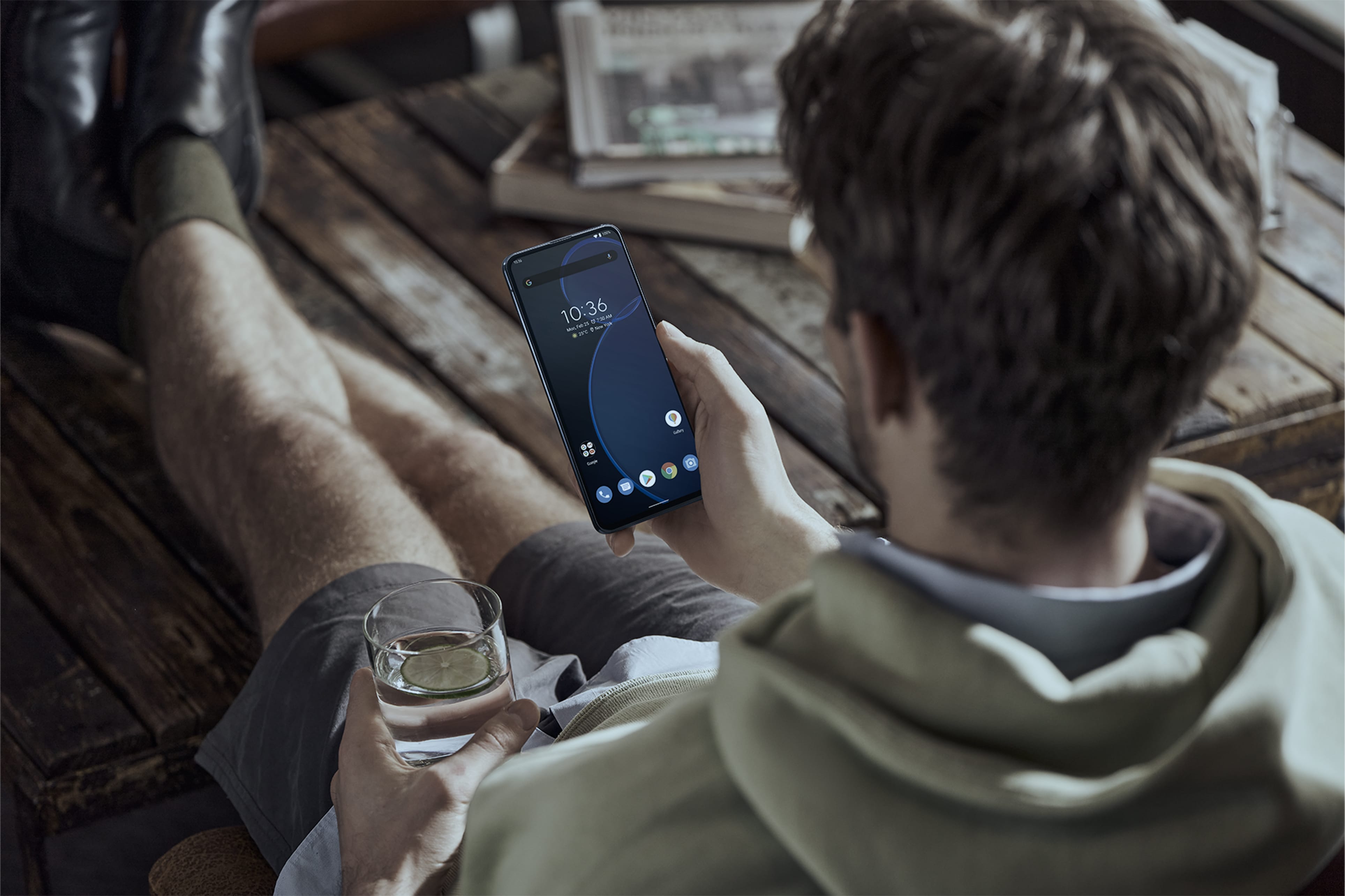 A man using Zenfone 8 with a cup of water in his hand